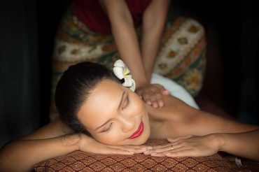 Masseur doing massage on Asian woman body in the spa salon